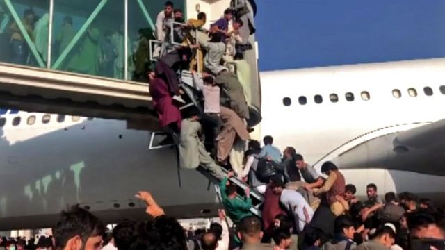 Kabil havalimanında uçağa tırmanan insanlar